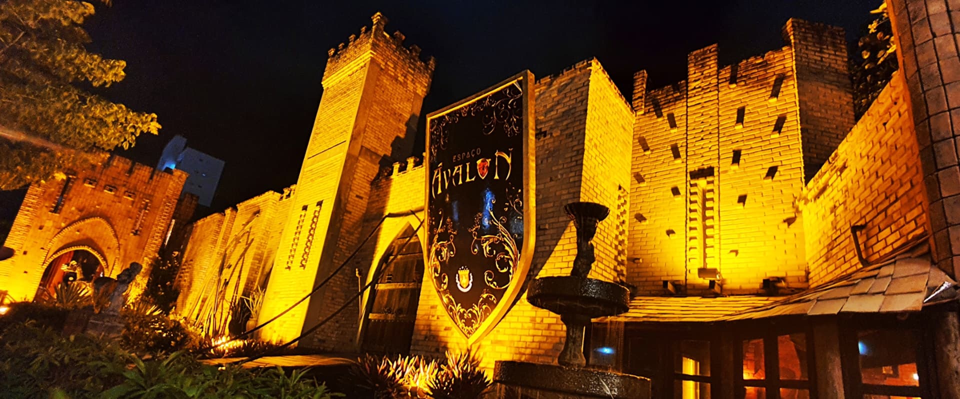 Fachada iluminada do Castelo Ávalon à noite